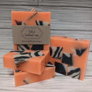 May include: A stack of four handmade soap bars with a zebra print design. The soap bars are a peach color with black and white zebra stripes. The top bar has a brown label that reads "Vollur handmade soap" and "Blackwell's Boutique".