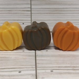 May include: Three small pumpkin-shaped wax melts in yellow, brown, and orange.