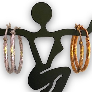 Può includere: Due paia di orecchini a cerchio, un paio è d'argento e l'altro è d'oro. Entrambe le paia hanno un design testurizzato.