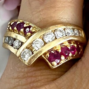 May include: A gold ring with a double row of diamonds and a double row of rubies. The ring is set in a twisted design.