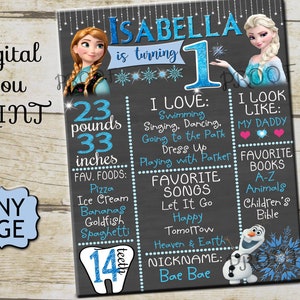 May include: A chalkboard style first birthday sign featuring a Frozen theme. The sign includes the name Isabella, age 1, weight 23 pounds, height 33 inches, favorite foods, favorite songs, favorite books, and a nickname. The sign is decorated with images of Elsa and Anna from Frozen.