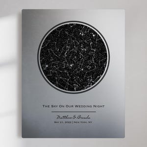 May include: A rectangular silver metal wall plaque featuring a circular black star map. The text reads: THE SKY ON OUR WEDDING NIGHT, Matthew & Brenda, MAY 21, 2022 | NEW YORK, NY. The design includes white constellations against a dark background.