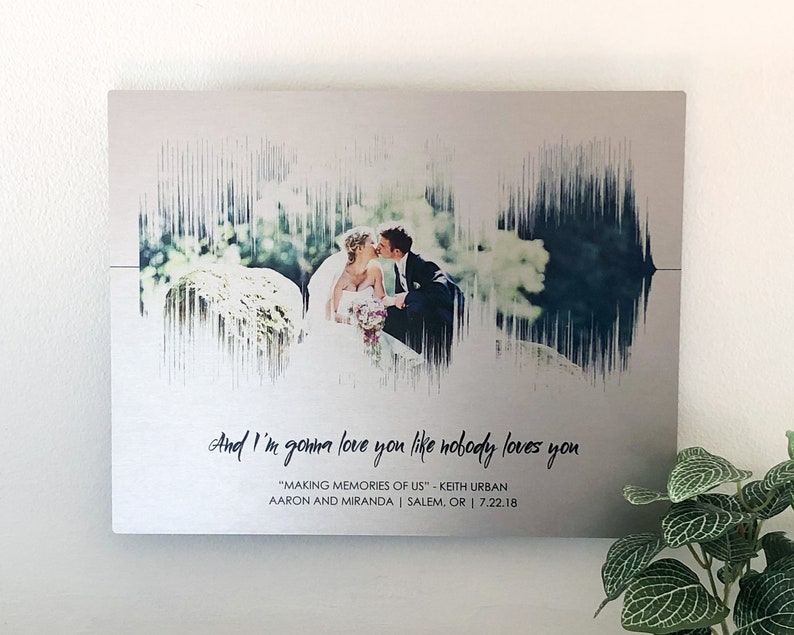 10 year anniversary gift. A photo of a couple is positioned inside the soundwave of a wedding song. It is printed a brushed aluminum and tin panel. Customized with any song and personalized with a lyric and personal text (names, location, date).