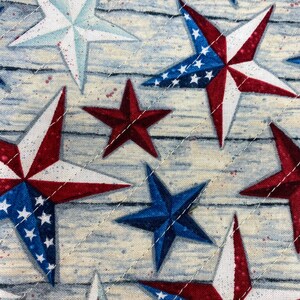 May include: A close-up of a fabric with a repeating pattern of red, white, and blue stars. The stars are arranged in a diagonal pattern on a light blue background.