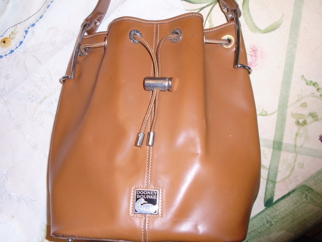 Dooney and Bourke Purse Drawstring Closure W Locking Slide Top Handle W metal Saddle Hardware Attachment Metal Tips Metal Plated Logo. Etsy
