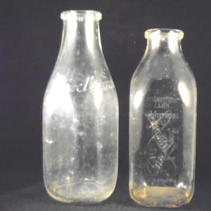 Dos botellas de leche de un cuarto de galón, Woodlawn Farm Dairy y Annandale Hunterdon Hills Quality Milk Woodlawn Farm Dairy, 9.5"H, Annandale 7.75"H.