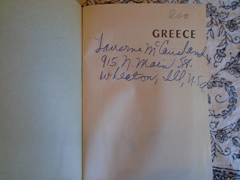 May include: A book titled "Greece" with handwritten inscription: "Laverne McLawsland 915 N. Main St. Wheaton, Ill. U.S.A."
