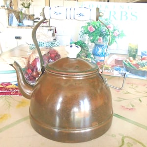 Bouilloire en cuivre, poignée en céramique bleue et blanche, couvercle. Bouilloire sur la cuisinière ou décoration. Intérieur en acier inoxydable propre. La poignée en laiton s'abaisse.