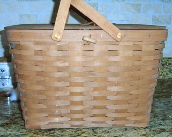 Longaberger Picnic Basket, w/ riser, large lidded, double handles. Lid has 2 leather straps and a leather buckle for closure.