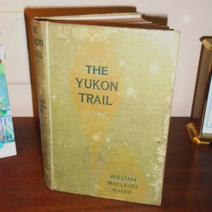 The Yukon Trail by William Macleod Raine. First Edition 1917, Good Condition. A tale of the North, w/ illus. by George Ellis Wolfe.