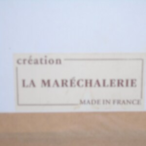 May include: A white label with brown text that reads "creation LA MAR&Eacute;CHALERIE MADE IN FRANCE".