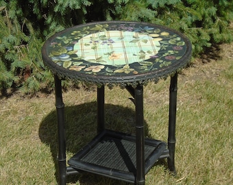 Tisch TRACY PORTER, Blumen, Insekten auf schwarzem, blaugrünem Gitter. Runder Tisch mit schwarzer Zierleiste, unterem Tablett und ausgestellten Beinen im Bambusstil