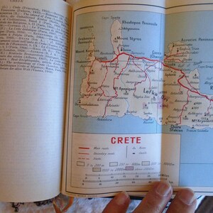 May include: A map of Crete, Greece, with red lines indicating major and secondary routes. The map shows the island's geography, including mountains, cities, and towns. The scale bar indicates distances in miles.