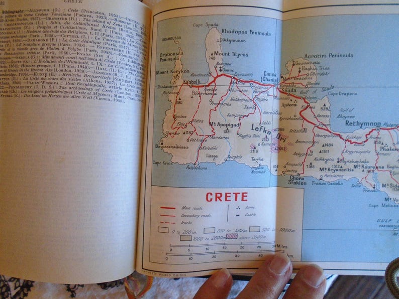 May include: A map of Crete, Greece, with red lines indicating major and secondary routes. The map shows the island's geography, including mountains, cities, and towns. The scale bar indicates distances in miles.
