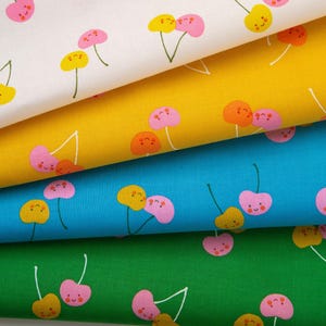 May include: Fabric samples with a repeating pattern of smiling cherries in pink and yellow. The fabric is layered in white, yellow, blue, and green. The cherries have green stems and are set against a solid background.