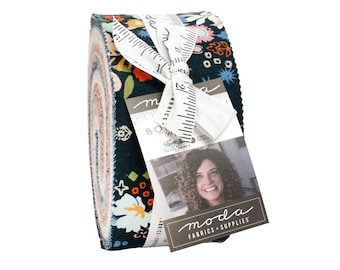 May include: A rolled bundle of fabric strips with a floral design in blue, orange, and white. The fabric is tied with a white ribbon and a tag with the text "moda FABRICS + SUPPLIES".