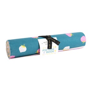 May include: A teal blue fabric roll with a pink and yellow strawberry print. The fabric roll is tied with a black ribbon and has a tag that says "Ruby Star Society Picture Book".