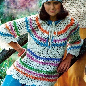 May include: A white crochet top with colorful stripes in shades of blue, green, orange, pink, and purple. The top has a tie at the neck and bell sleeves.