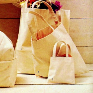 May include: Several cream-coloured canvas tote bags of different sizes. One large tote has a front pocket with art supplies. Another bag contains flowers. A doll rests in a matching canvas bassinet.