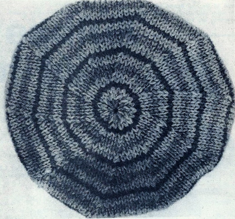 Peut inclure: Un tapis rond bleu en tricot avec un motif circulaire. Le tapis a une surface textur&eacute;e et est fait de fil.