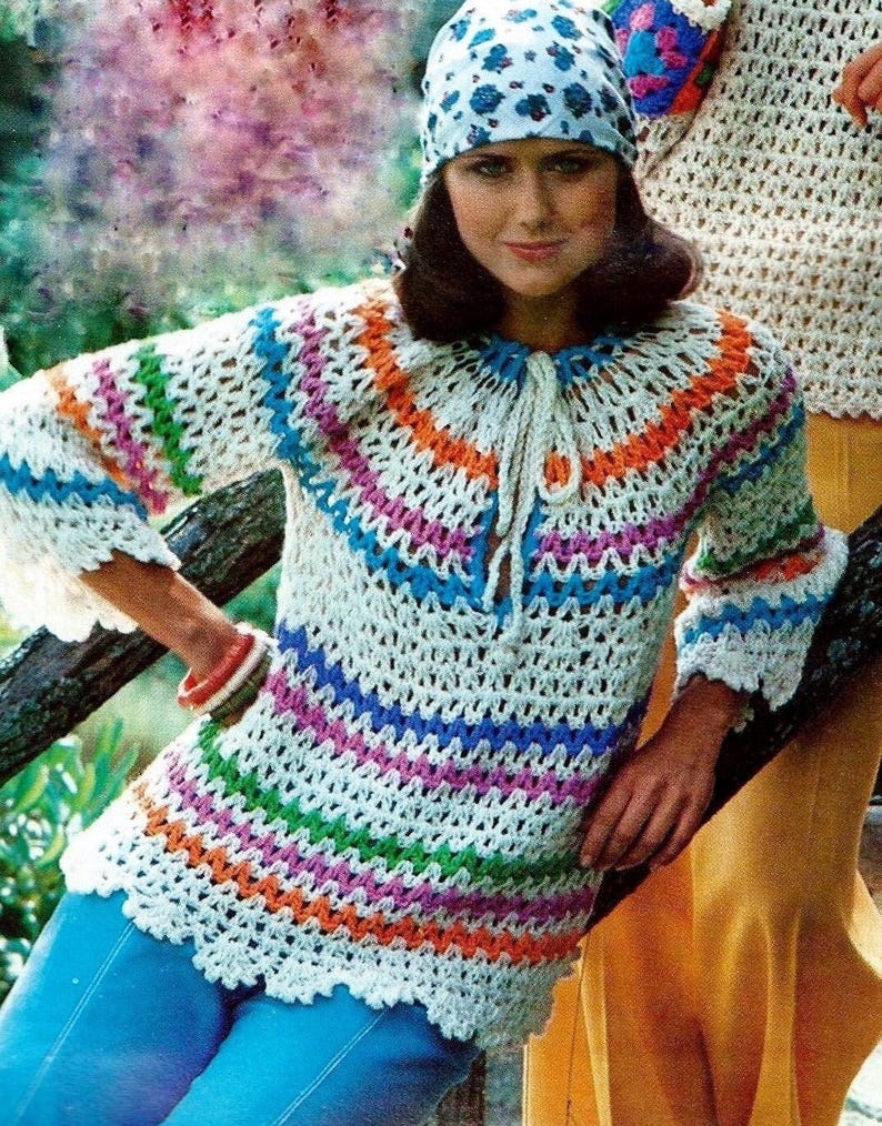 May include: A white crochet top with colorful stripes in shades of blue, green, orange, pink, and purple. The top has a tie at the neck and bell sleeves.