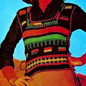 Peut inclure: Un gilet crocheté avec un motif géométrique coloré dans les tons de rouge, vert, jaune et noir. Le gilet a un col carré et un bas frangé.