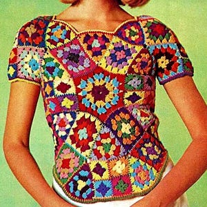 Puede incluir: Un top de crochet colorido con un dise&ntilde;o de patchwork que presenta varios tonos de rojo, azul, verde, amarillo y morado. El top tiene mangas cortas y un escote redondo.