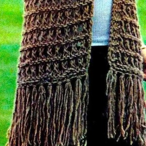 May include: A brown crocheted scarf with long fringe on the ends. The scarf is made with a textured stitch pattern.