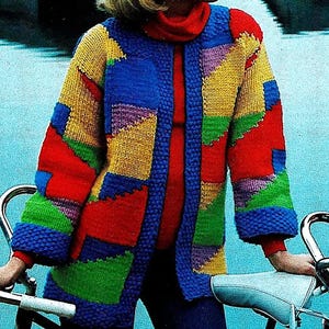 Puede incluir: Un cárdigan de punto colorido con un patrón geométrico en tonos de rojo, amarillo, azul, verde y morado. El cárdigan tiene una abertura larga en la parte delantera y mangas largas.