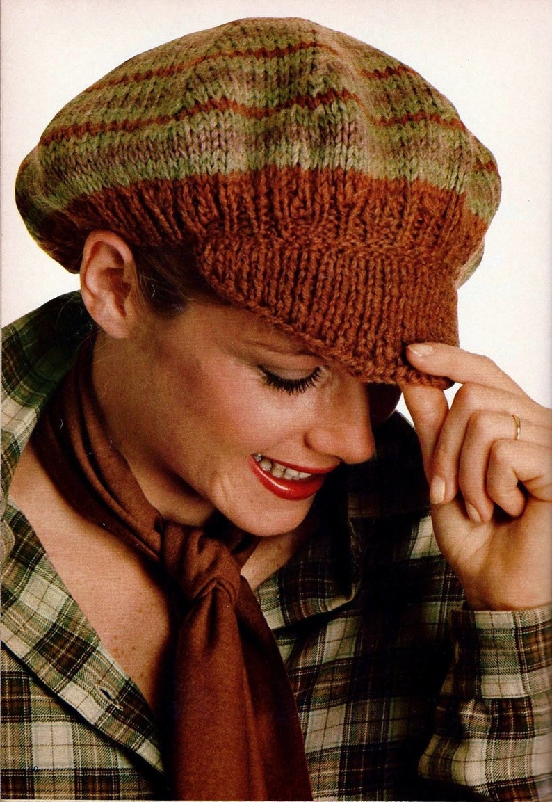 Peut inclure: Une femme portant un b&eacute;ret en tricot ray&eacute; marron et vert avec une &eacute;charpe marron et une chemise &agrave; carreaux.