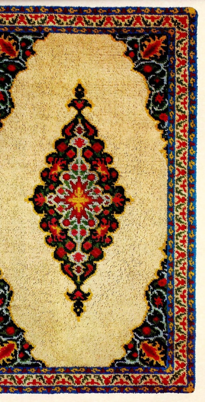 May include: A cream-colored rug with a colorful floral design. The rug has a dark blue border with red, green, and yellow accents.