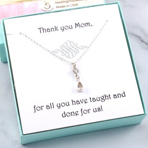 May include: A silver necklace with a teardrop pendant is presented in a pale blue gift box. The card inside reads "Thank you Mom, for all you have taught and done for us!"