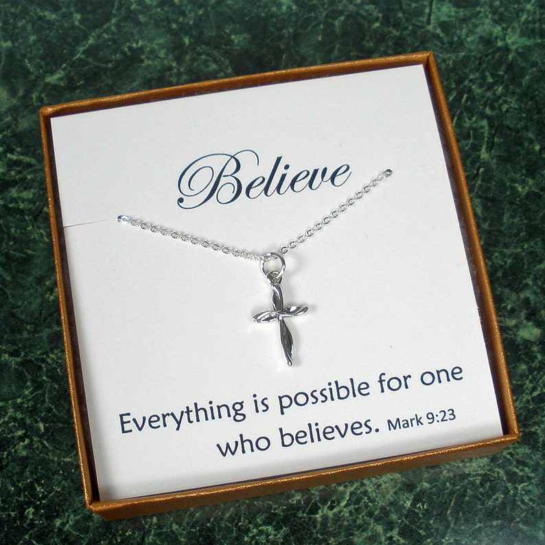 May include: A silver necklace with a small, twisted cross pendant. The necklace comes in a box with a white card that reads "Believe" and "Everything is possible for one who believes. Mark 9:23".