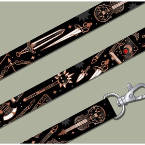 May include: Black and copper lanyard with a repeating pattern of various fantasy weapons and a violin. The lanyard has a silver swivel clip.
