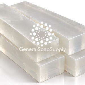 May include: Three rectangular blocks of clear, translucent melt and pour soap base stacked together. The text GeneralSoapSupply is printed in white on the front block, accompanied by a circular logo made of small white dots.