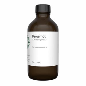 May include: A brown glass bottle with a black cap, labeled "Bergamot (Citrus bergamia)" and "Cold Pressed Essential Oil." The label also indicates a 4 oz (118ml) volume. The bottle has a white label with green accents.