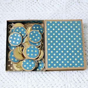 Guirlande papier bleu à pois dorés et perles dorées avec sa jolie  boite en kraft