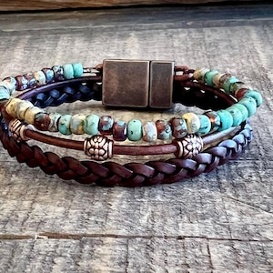 May include: A multi-layered bracelet with brown leather and turquoise and brown beads. The bracelet has a magnetic clasp.