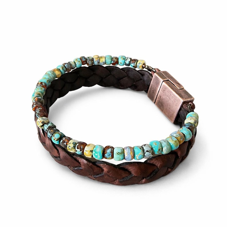 Braided brown leather bracelet with turquoise and brown beads. The bracelet features a magnetic clasp. The beads are a mix of blue, green, and brown. The leather is a dark brown color.