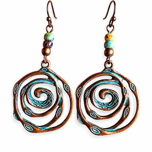 May include: A pair of copper-toned earrings with a spiral design and turquoise detailing. Each earring has a series of colourful beads and a hook fastening. The earrings have an openwork design with a vintage aesthetic.