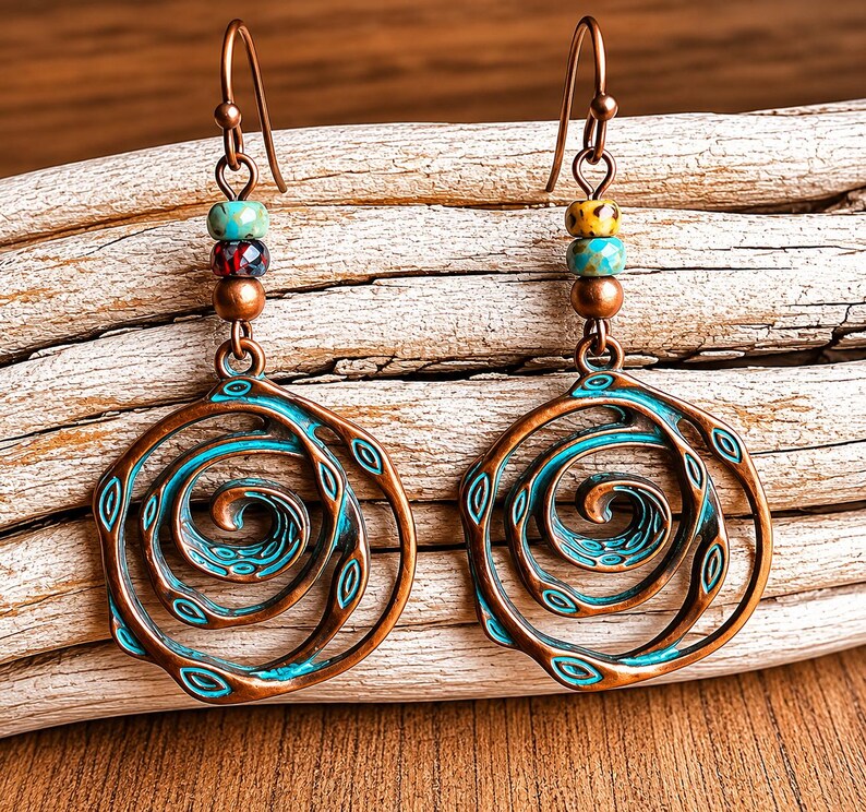 May include: A pair of copper-toned earrings with a spiral design. The earrings feature a turquoise and copper colour scheme, with a series of colourful beads at the top. The spiral design is accented with turquoise details, creating a unique and artistic look.