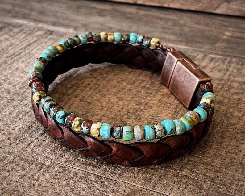 Braided brown leather bracelet with turquoise and multicolored beads. The bracelet features a copper-colored magnetic clasp. The beads are a mix of blue, green, yellow, and red.