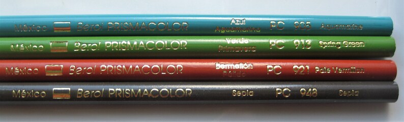 Op de afbeelding: Vier Prismacolor kleurpotloden met de merknaam en "Mexico" erop gedrukt. De potloden zijn gelabeld met de kleuren "Azul Aguamarina", "Verde Primavera", "Bermell&oacute;n P&aacute;lido" en "Sepia".