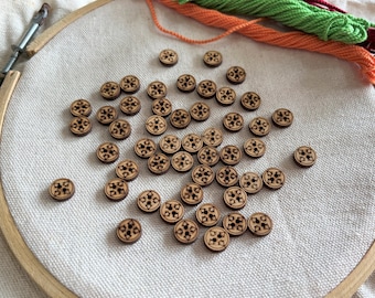 May include: A collection of wooden buttons with a decorative design. The buttons are brown and have a floral pattern.
