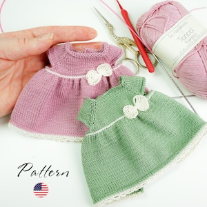 Pode incluir: Dois vestidos de boneca de malha, um rosa e outro verde, com laços e acabamentos brancos. Os vestidos são exibidos com materiais de tricô, incluindo fios, tesouras e agulhas. A palavra "Pattern" está escrita na imagem.