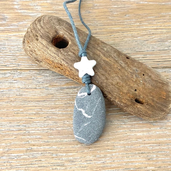 Raw stone star pendant necklace handmade using a natural Cornish beach stone, and a ceramic star on an adjustable grey waxed cotton cord