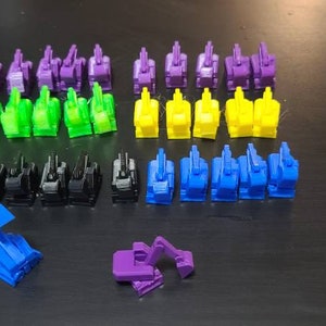 May include: A collection of 30 small plastic toy construction vehicles in various colors, including green, blue, yellow, purple, and black. The vehicles are arranged in rows on a black surface.