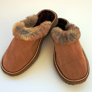 Women brown slippers made with leather and fur on top. The inside is made with fur and will keep your foot warm, a great gift for her