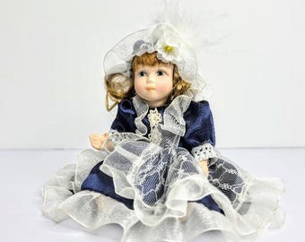 Vintage Porcelain Doll in White Blue Floral Dress, Smiling