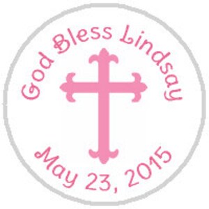 May include: A white circle with a pink cross in the center. The text "God Bless Lindsay May 23, 2015" is written around the cross.